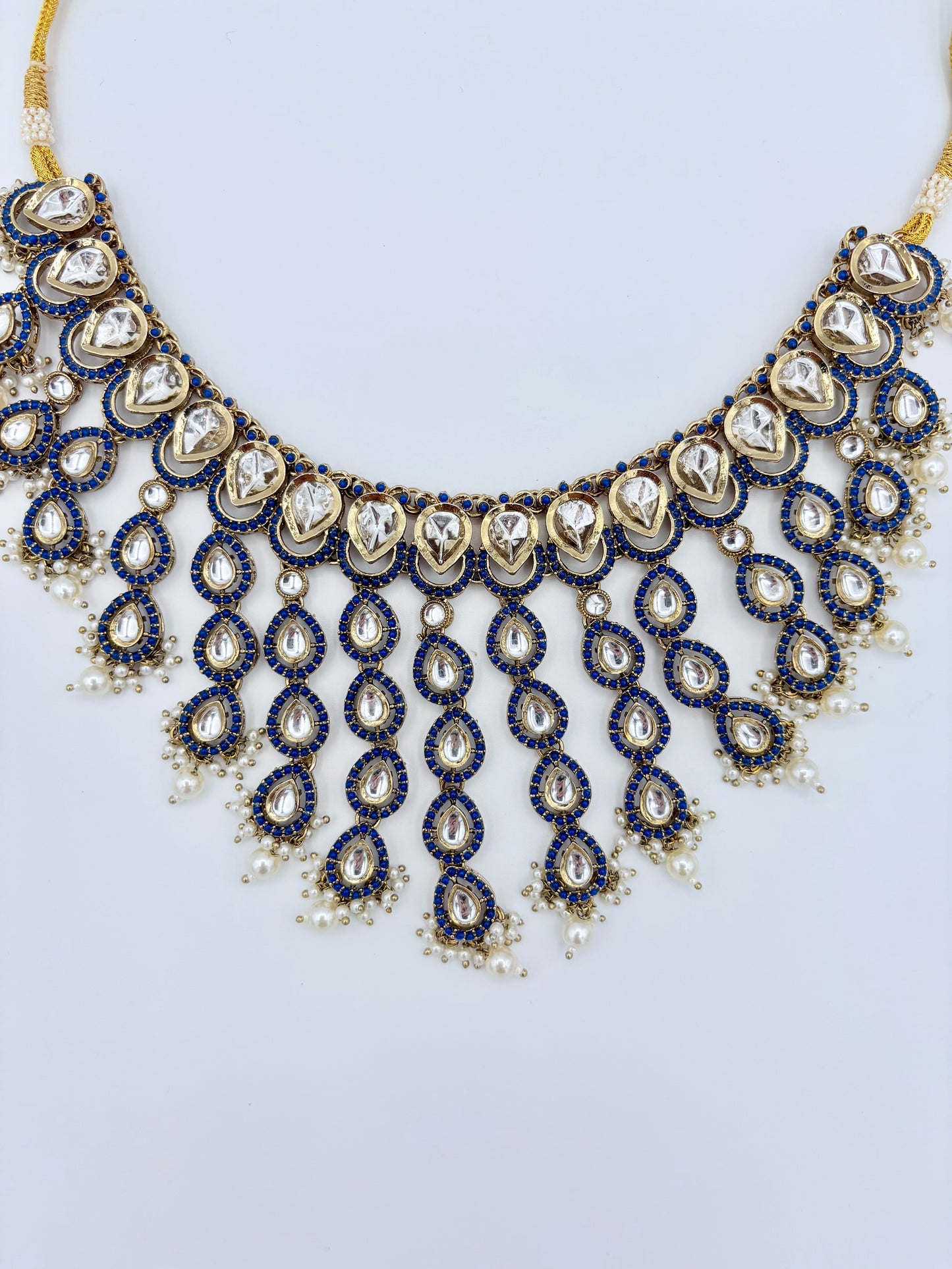 Ornate necklace with blue and gold accents on a light gray background available at Nishaani.ca – Indian jewelry in Canada