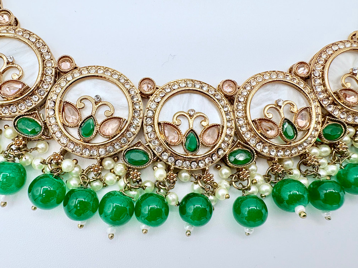 Ornate necklace with green beads and gold accents on a white background available at Nishaani.ca – Indian jewelry in Canada