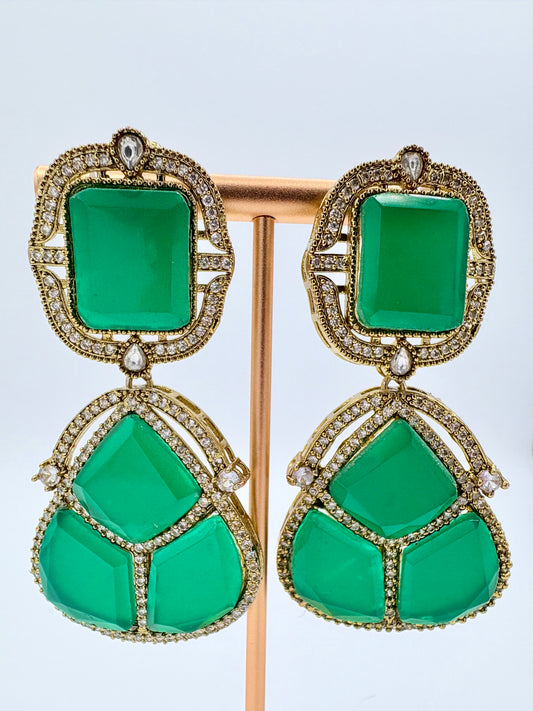 Pair of green earrings with gold and diamond accents on a stand available at Nishaani.ca – Indian jewelry in Canada