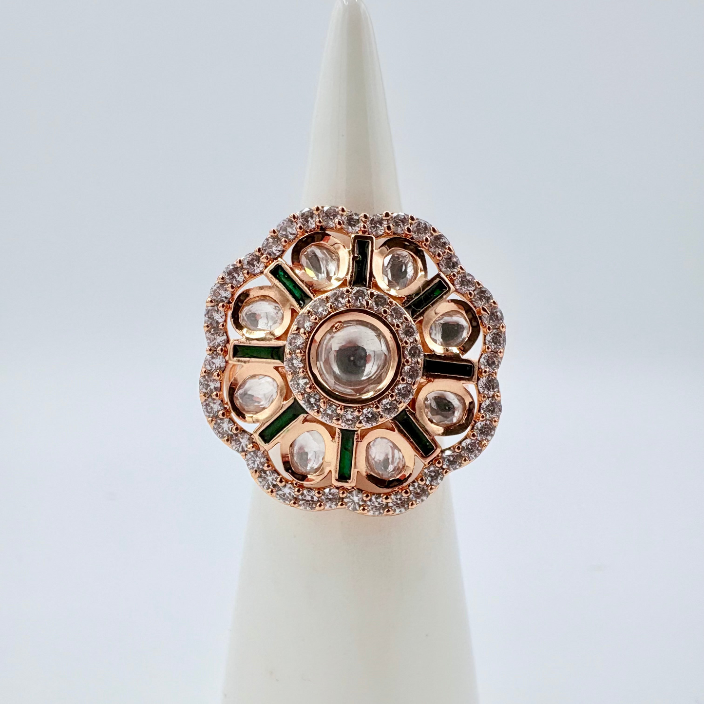 Decorative ring with gemstones on a white cone stand against a light gray background available at Nishaani.ca – Indian jewelry in Canada