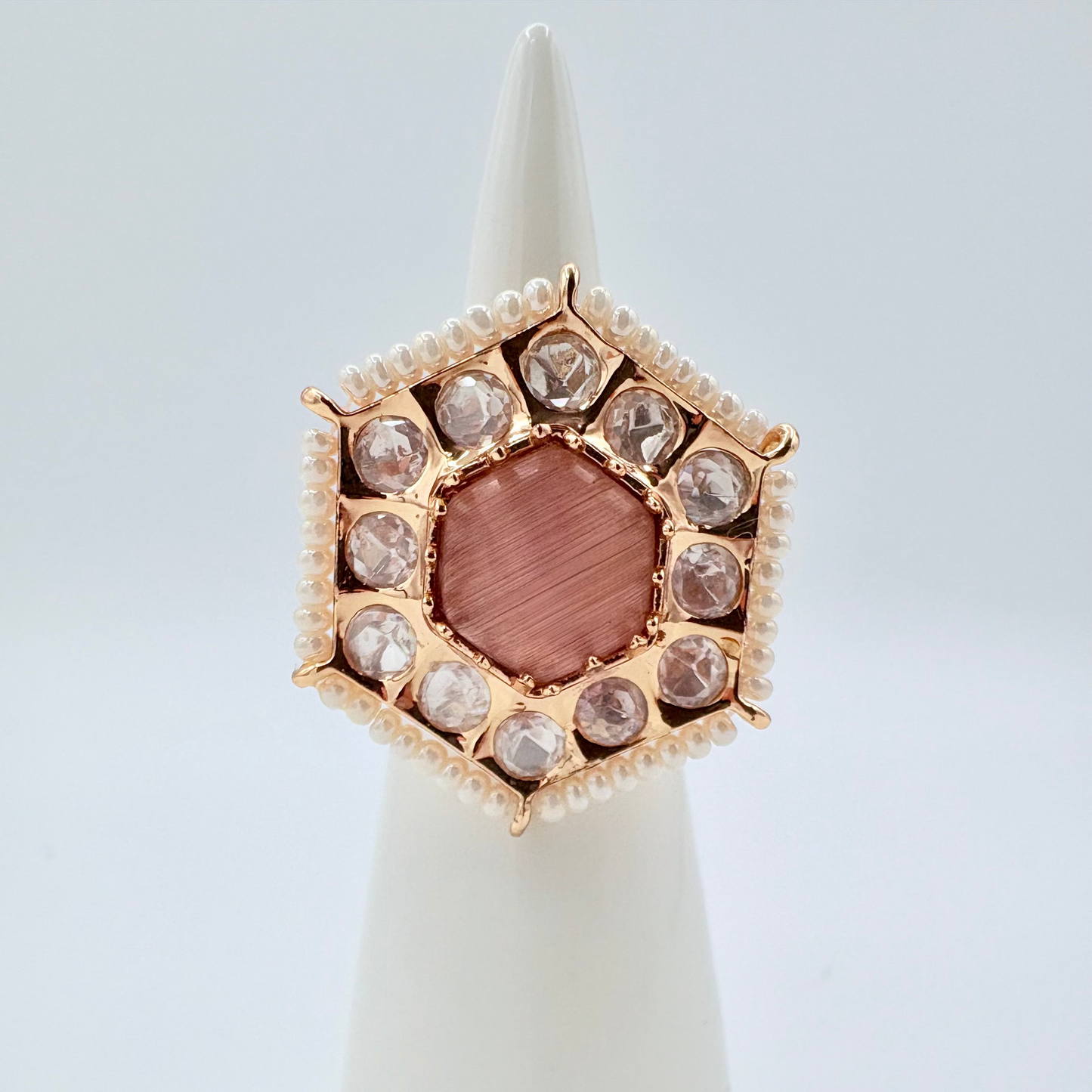 Gold ring with a rose gemstone surround by small crystal gems available at Nishaani.ca – Indian jewelry in Canada