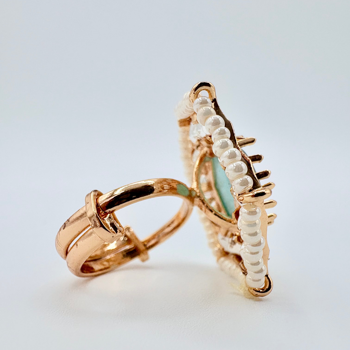 Side view Gold ring with a icy blue gemstone surround by small crystal gems available at Nishaani.ca – Indian jewelry in Canada