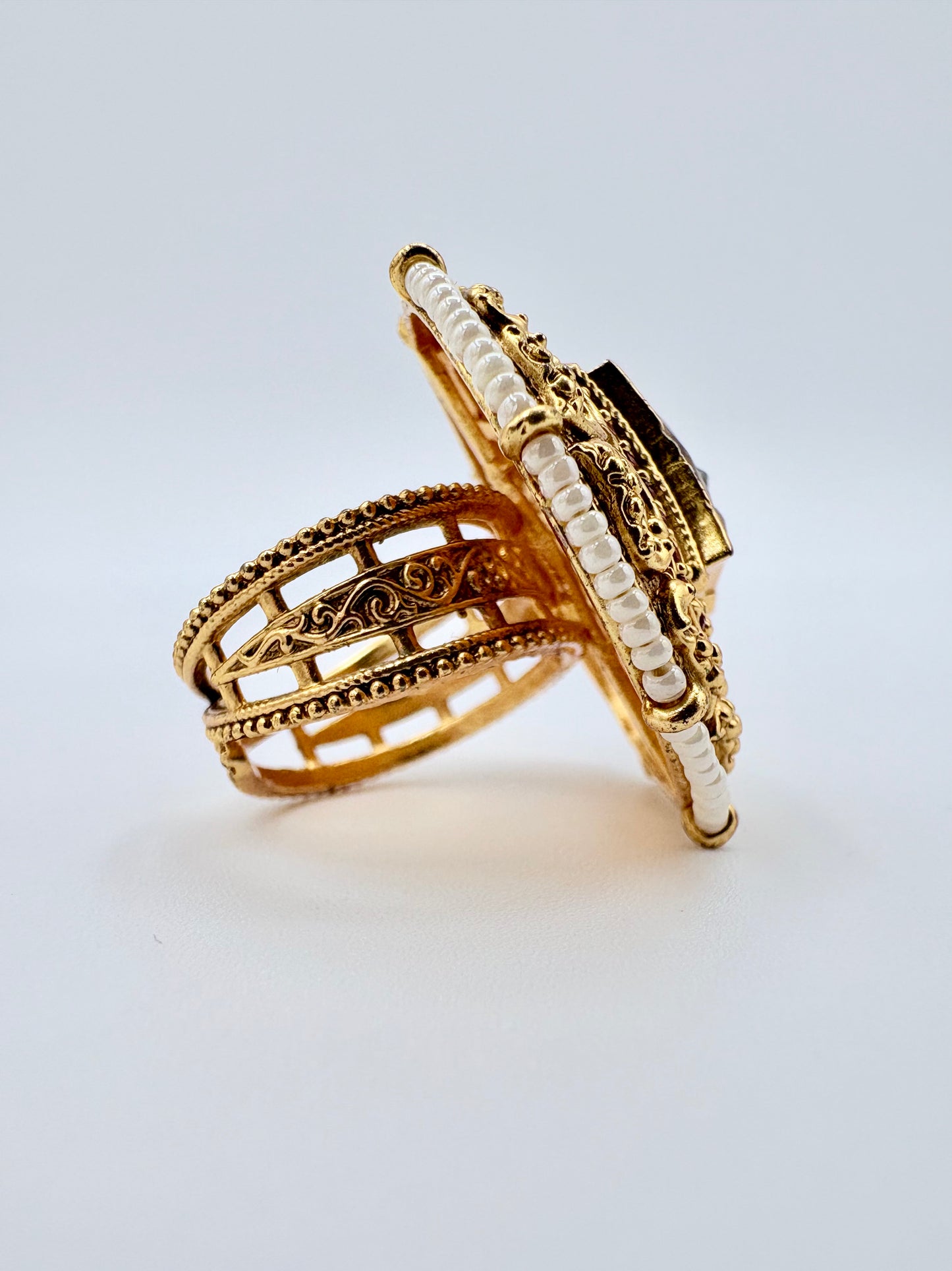 Gold ring with intricate design on a light available at Nishaani.ca – Indian jewelry in Canada