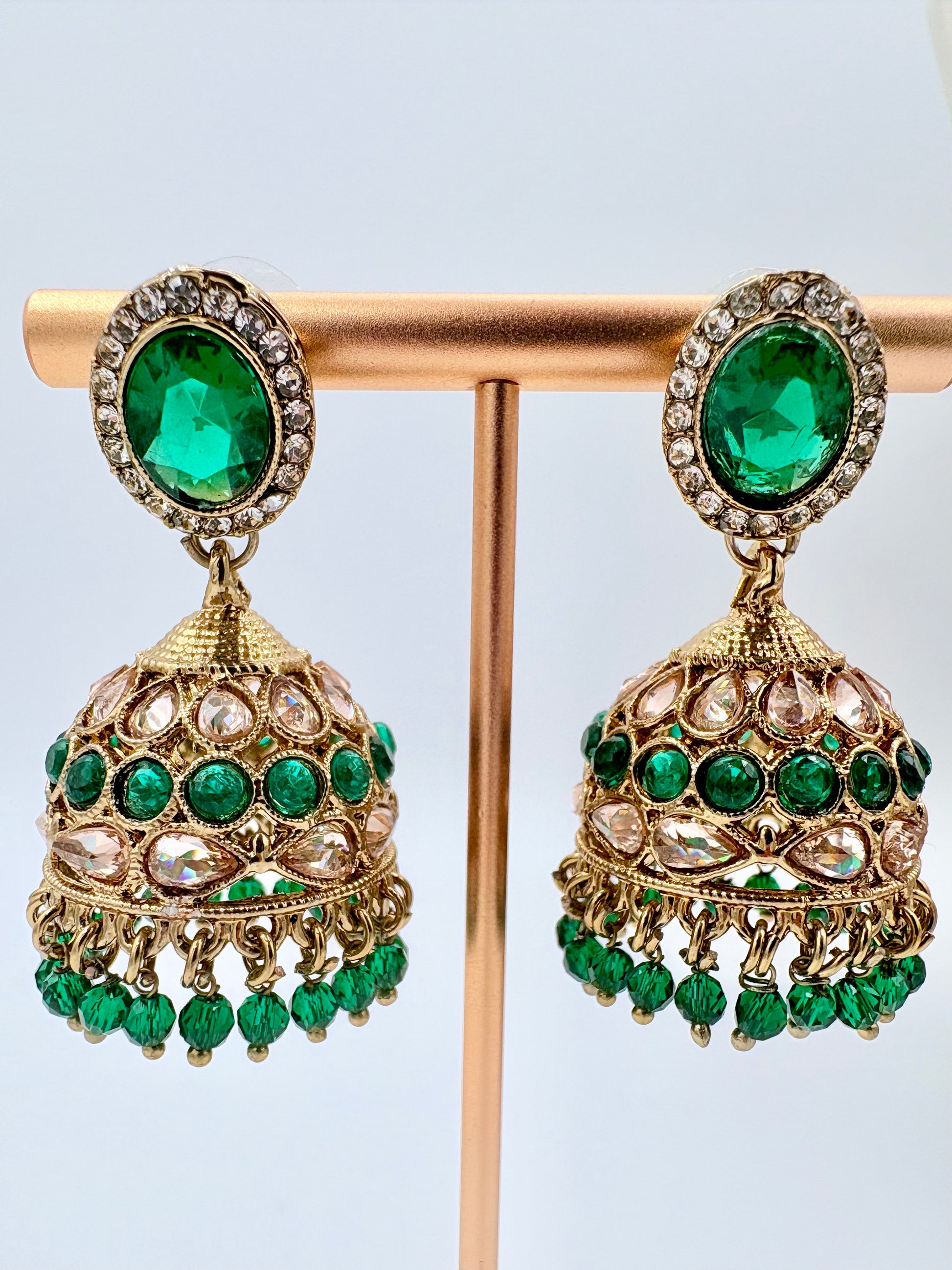 Pair of gold and green earrings on a stand available at Nishaani.ca – Indian jewelry in Canada