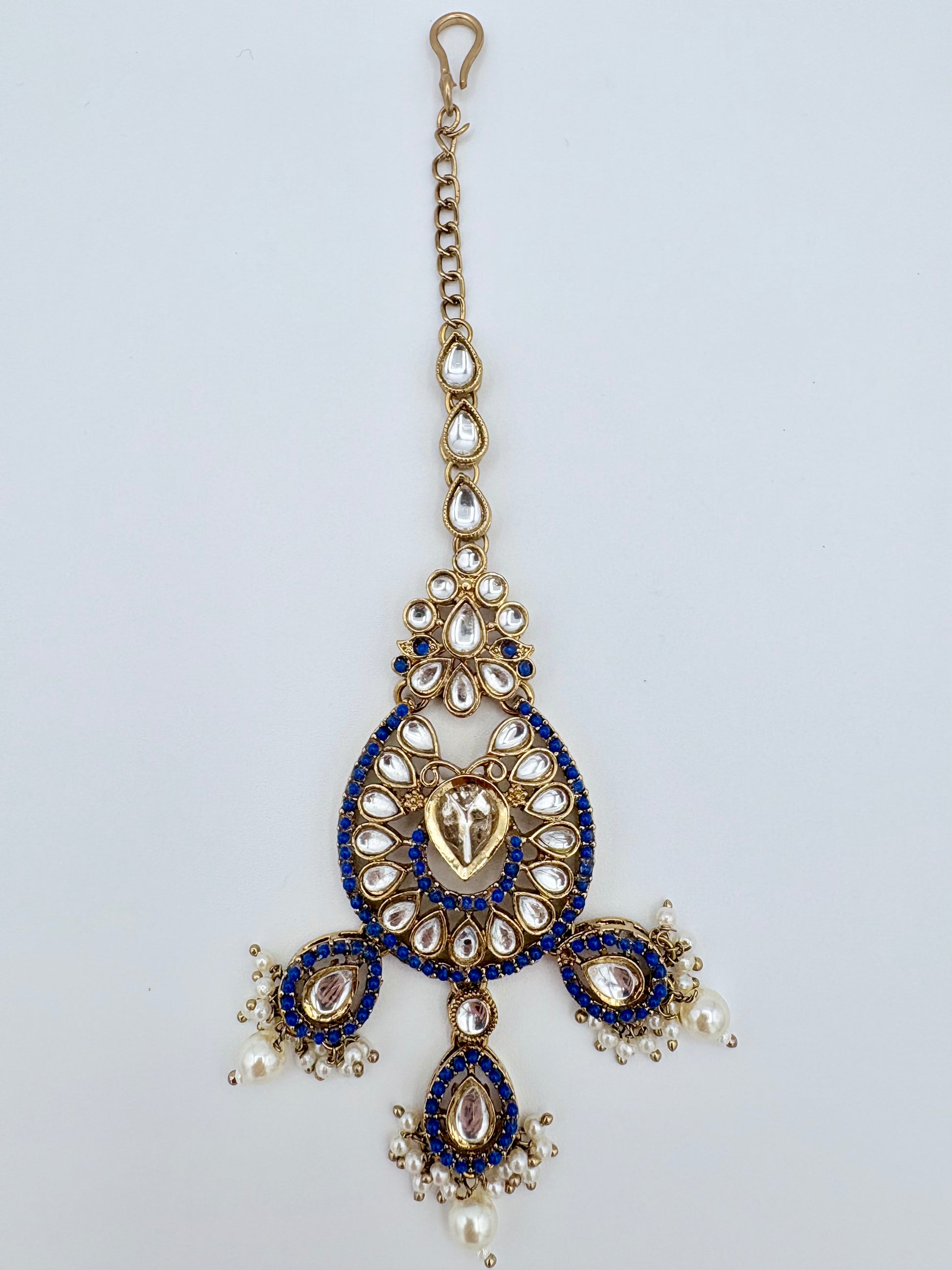 Tikka with blue and gold design on a light gray background