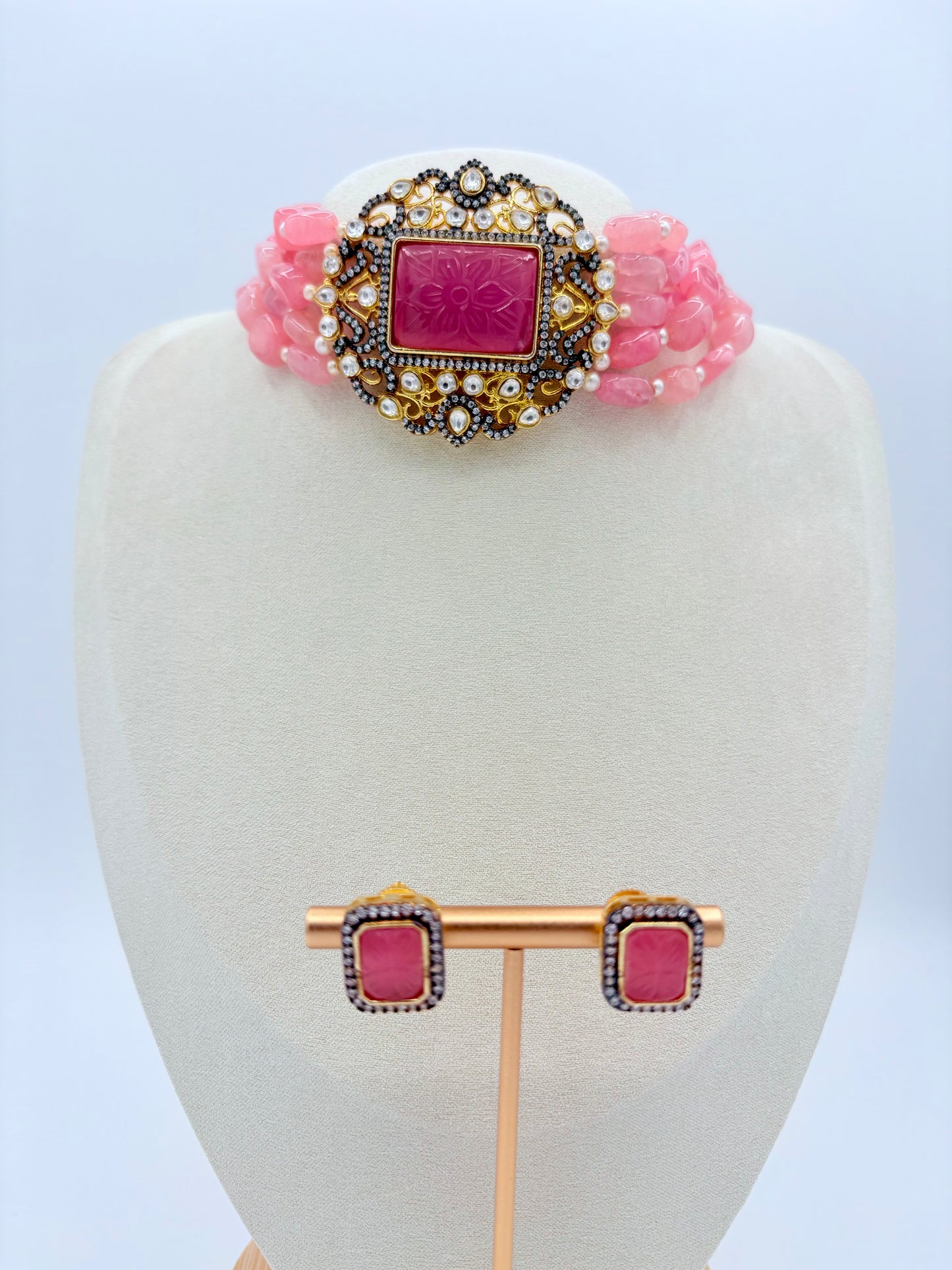 Jewelry set with pink and gold design on a white mannequin bust available at Nishaani.ca – Indian jewelry in Canada