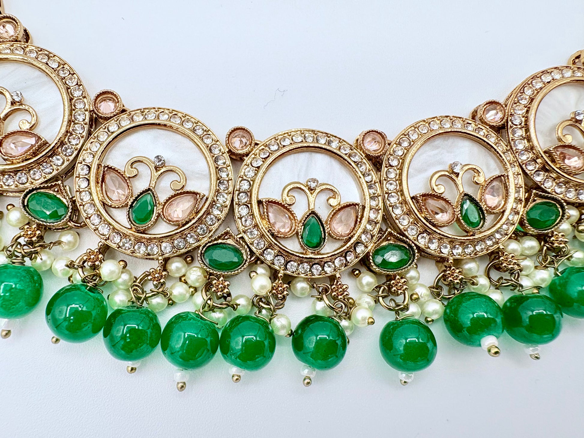 Ornate necklace with green beads and gold accents on a white background available at Nishaani.ca – Indian jewelry in Canada