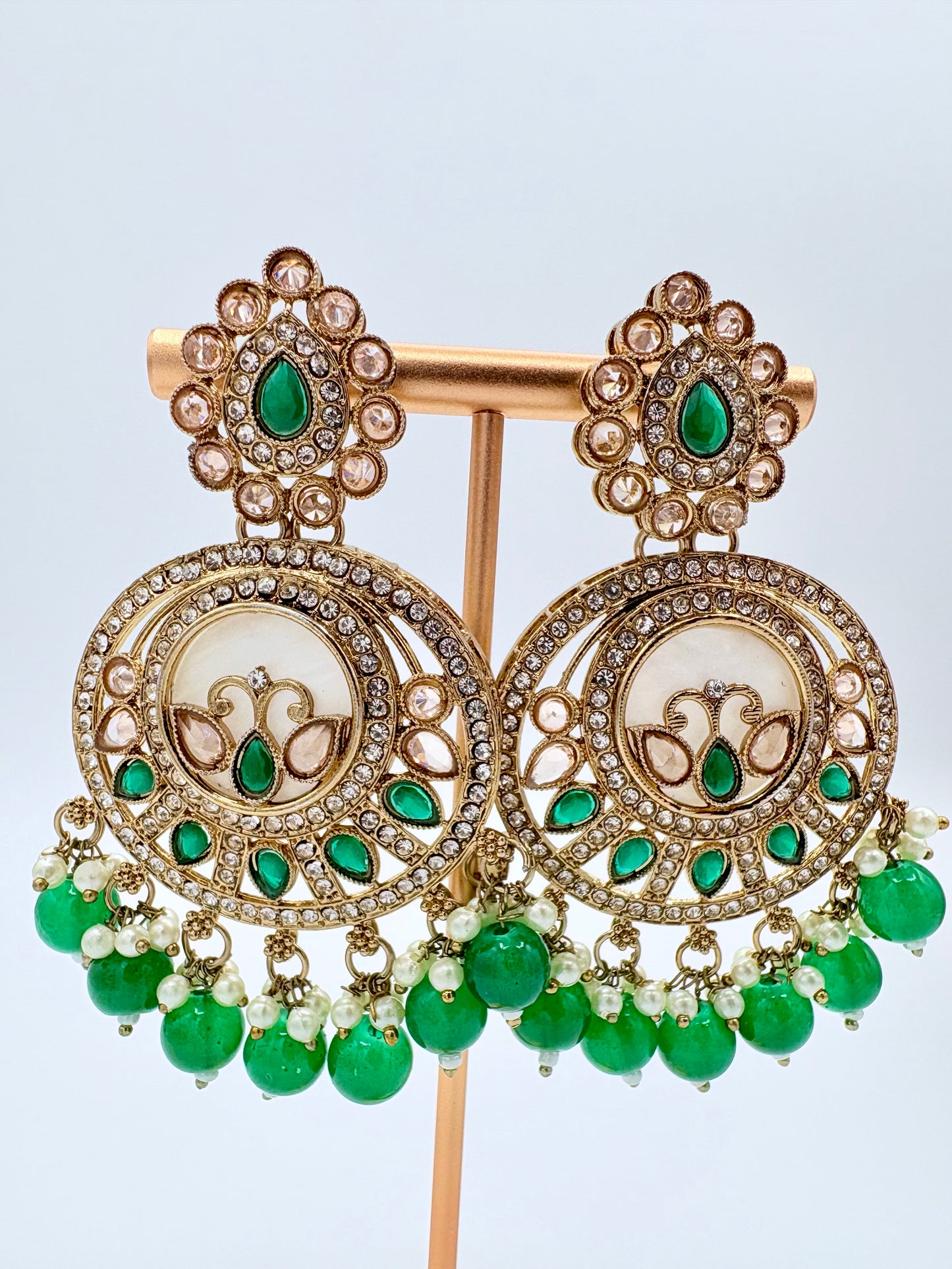 Pair of ornate earrings with green gemstones available at Nishaani.ca – Indian jewelry in Canada