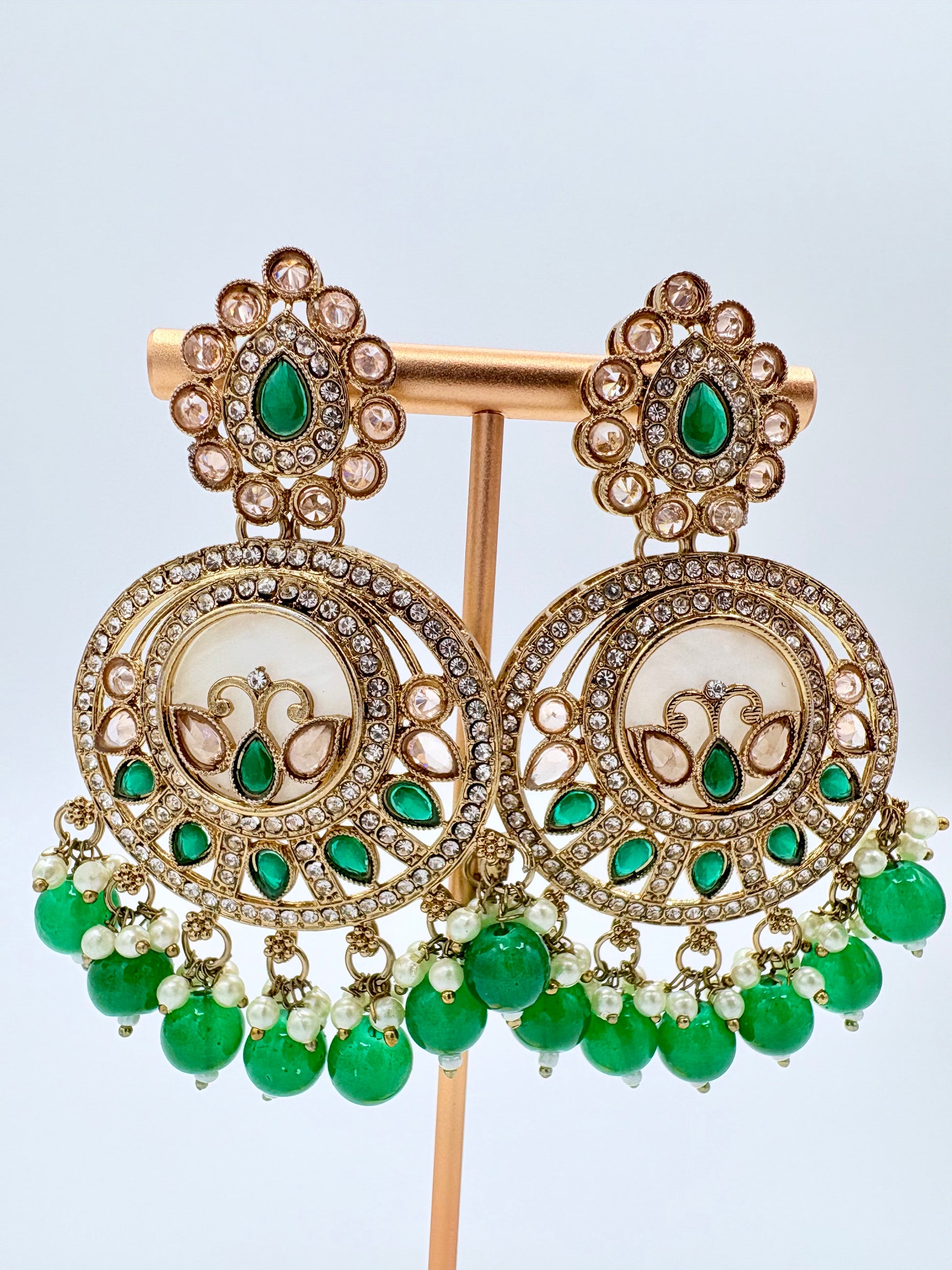 Pair of ornate earrings with green gemstones available at Nishaani.ca – Indian jewelry in Canada