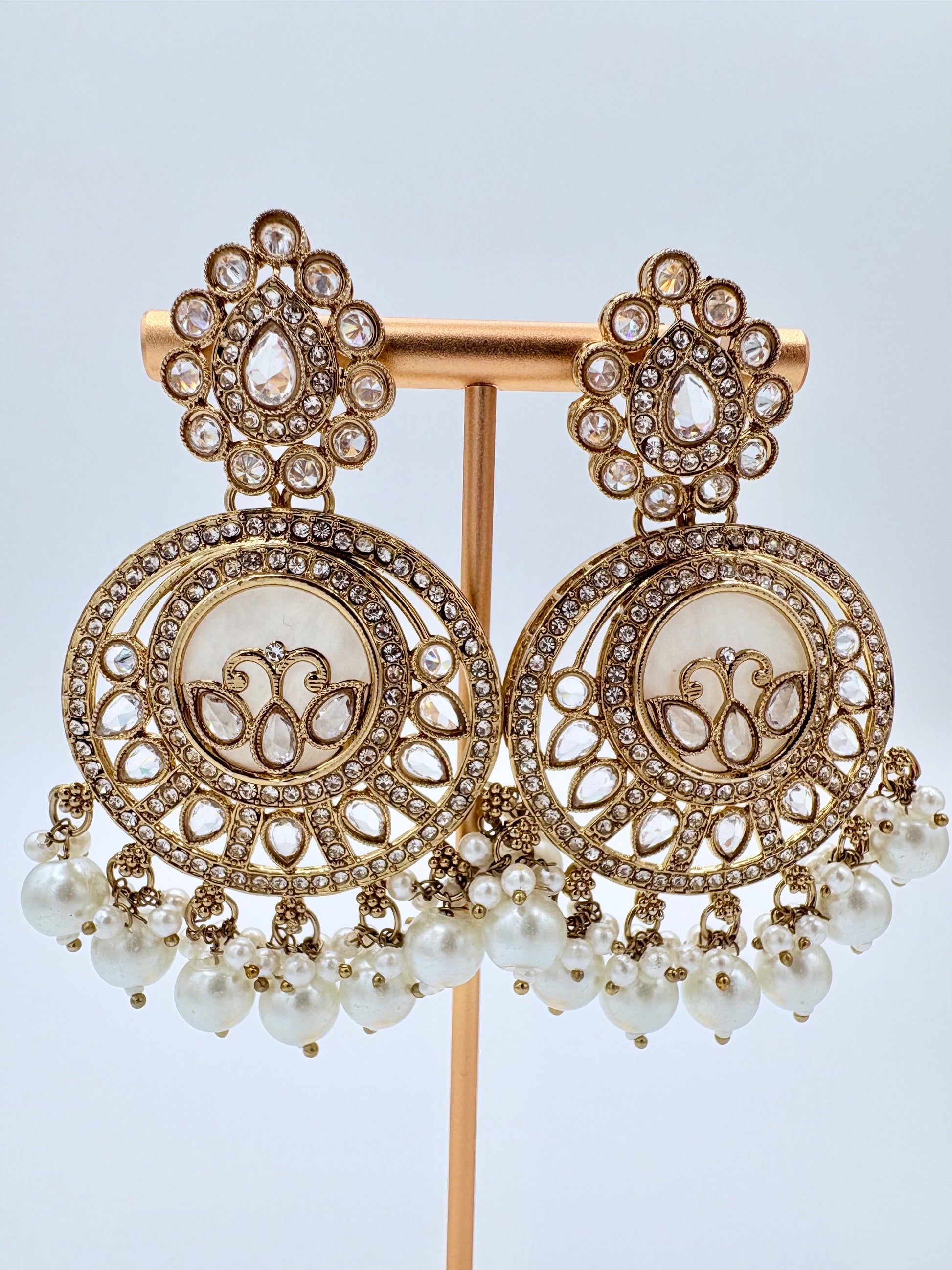 Gold and pearl earrings on a stand available at Nishaani.ca – Indian jewelry in Canada