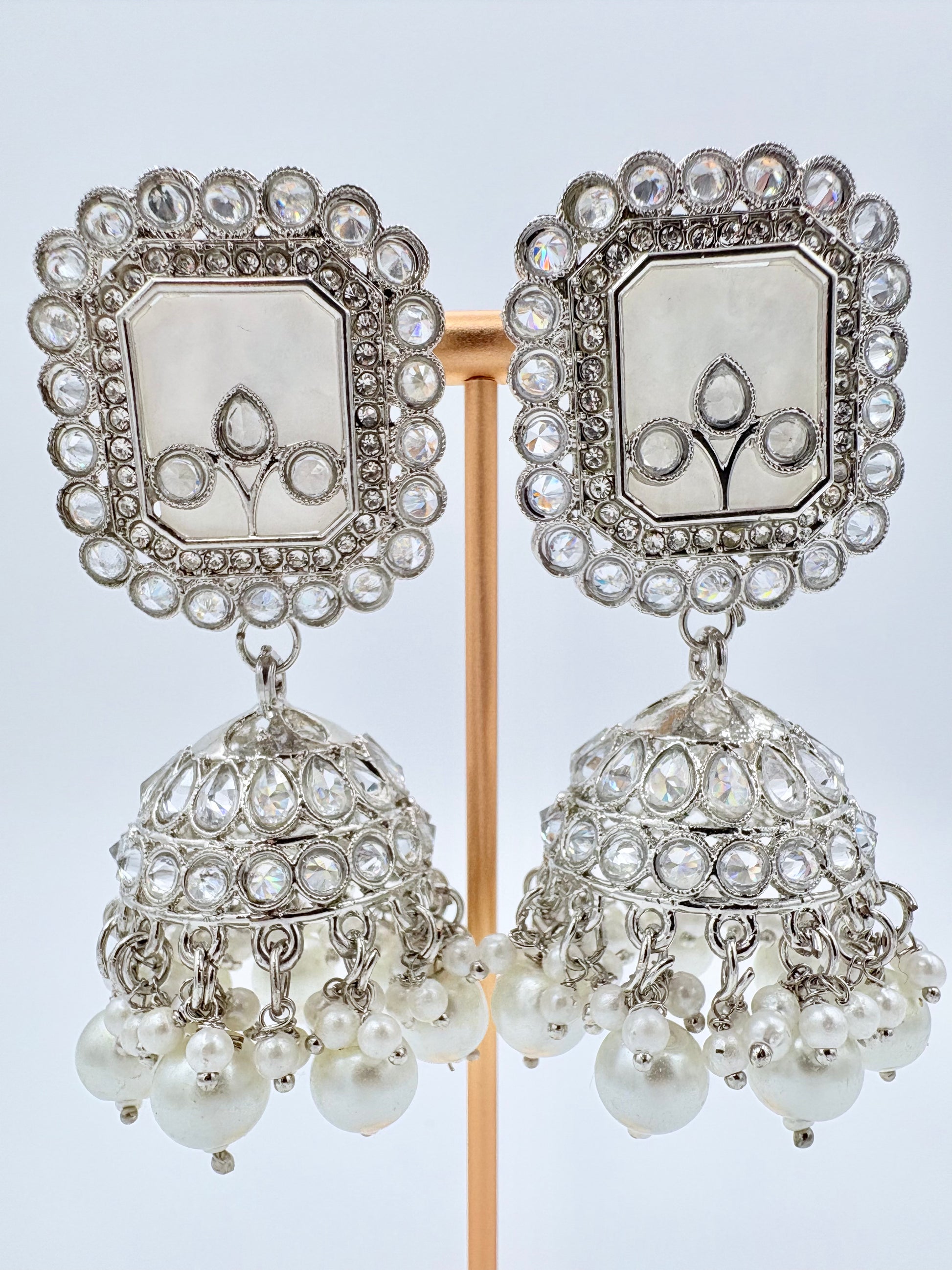 Pair of silver and pearl earrings on a stand available at Nishaani.ca – Indian jewelry in Canada