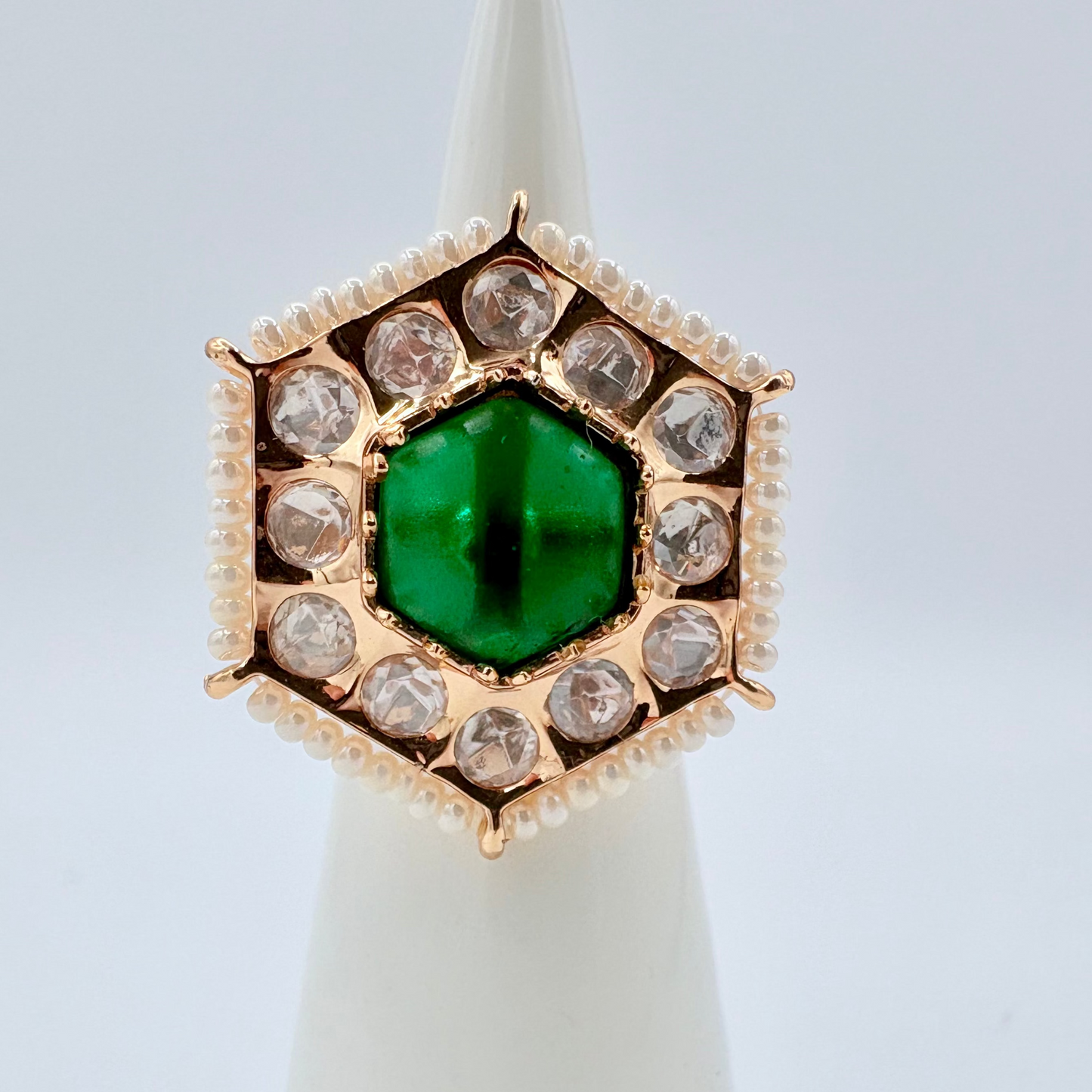 Gold ring with a green gemstone surround by small crystal gems available at Nishaani.ca – Indian jewelry in Canada