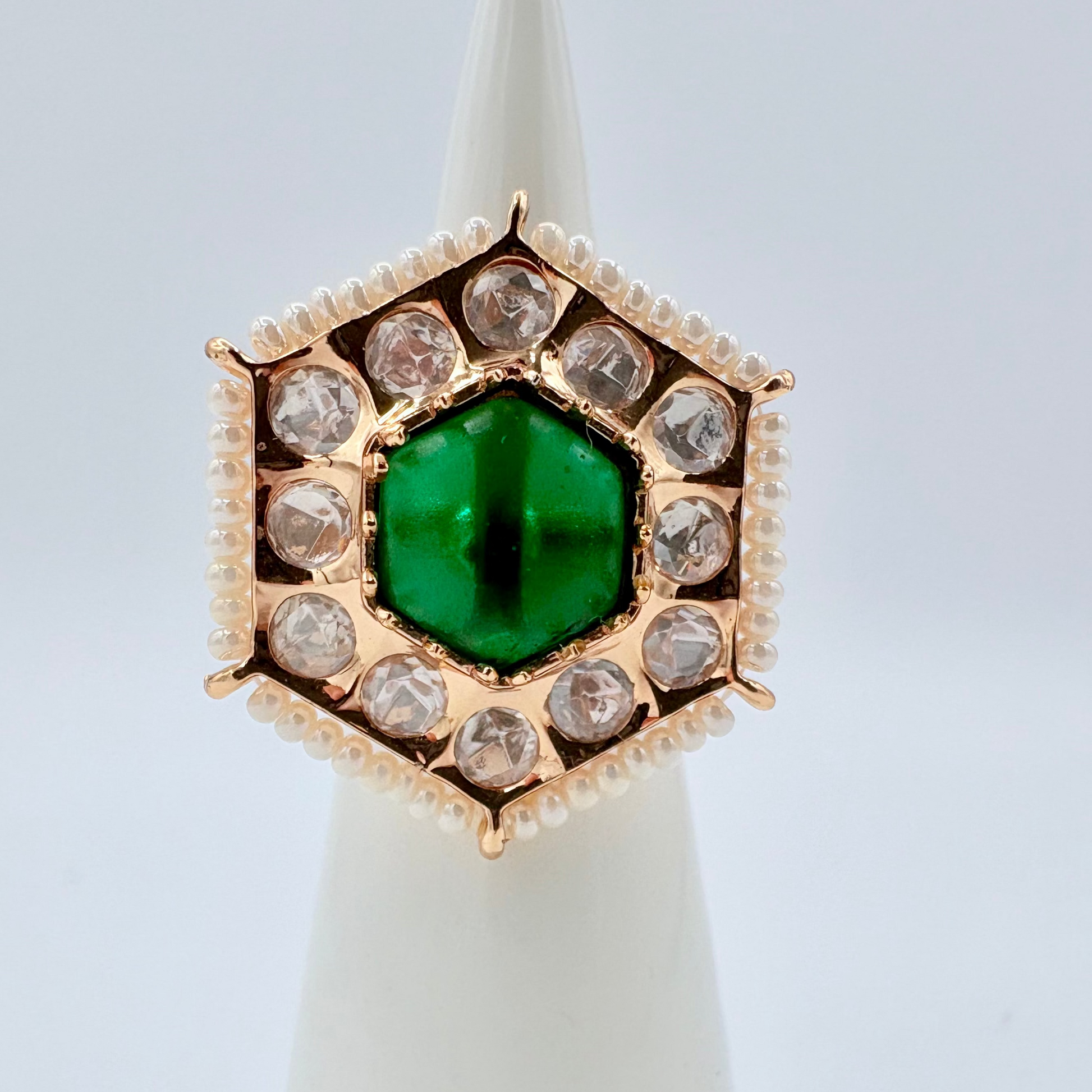 Gold ring with a green gemstone surround by small crystal gems available at Nishaani.ca – Indian jewelry in Canada