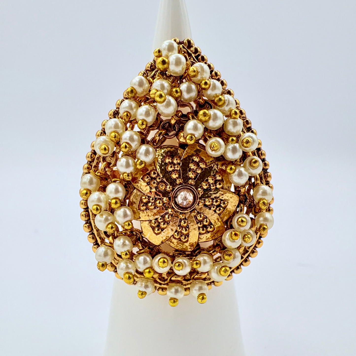 Beautiful  ring with gold and pearl design on a white stand available at Nishaani.ca – Indian jewelry in Canada