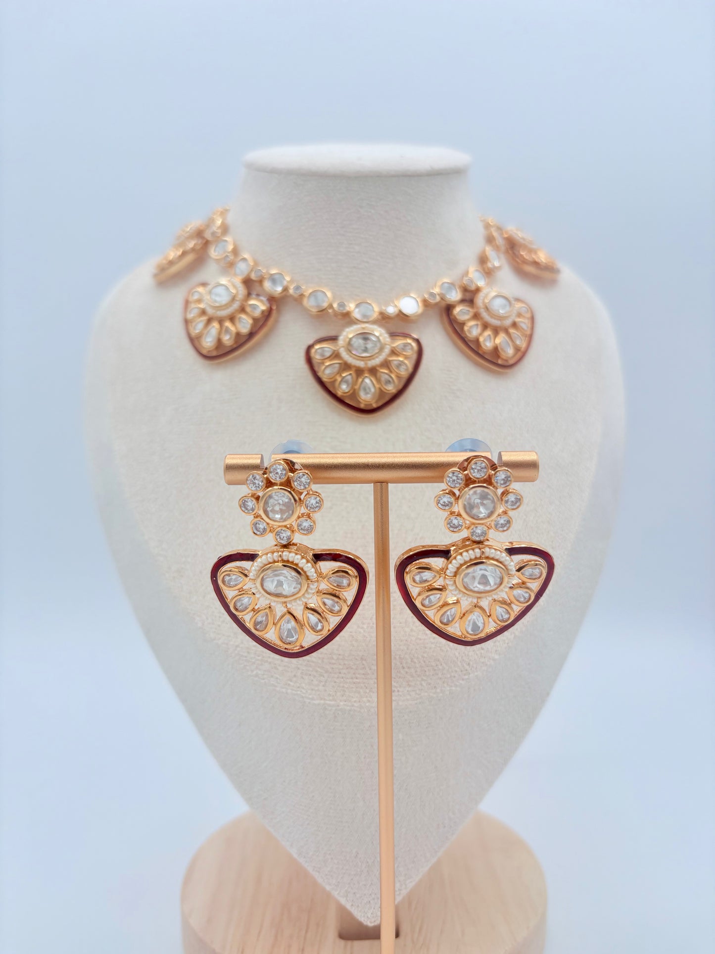 Gold and red jewelry set on a mannequin bust available at Nishaani.ca – Indian jewelry in Canada 
