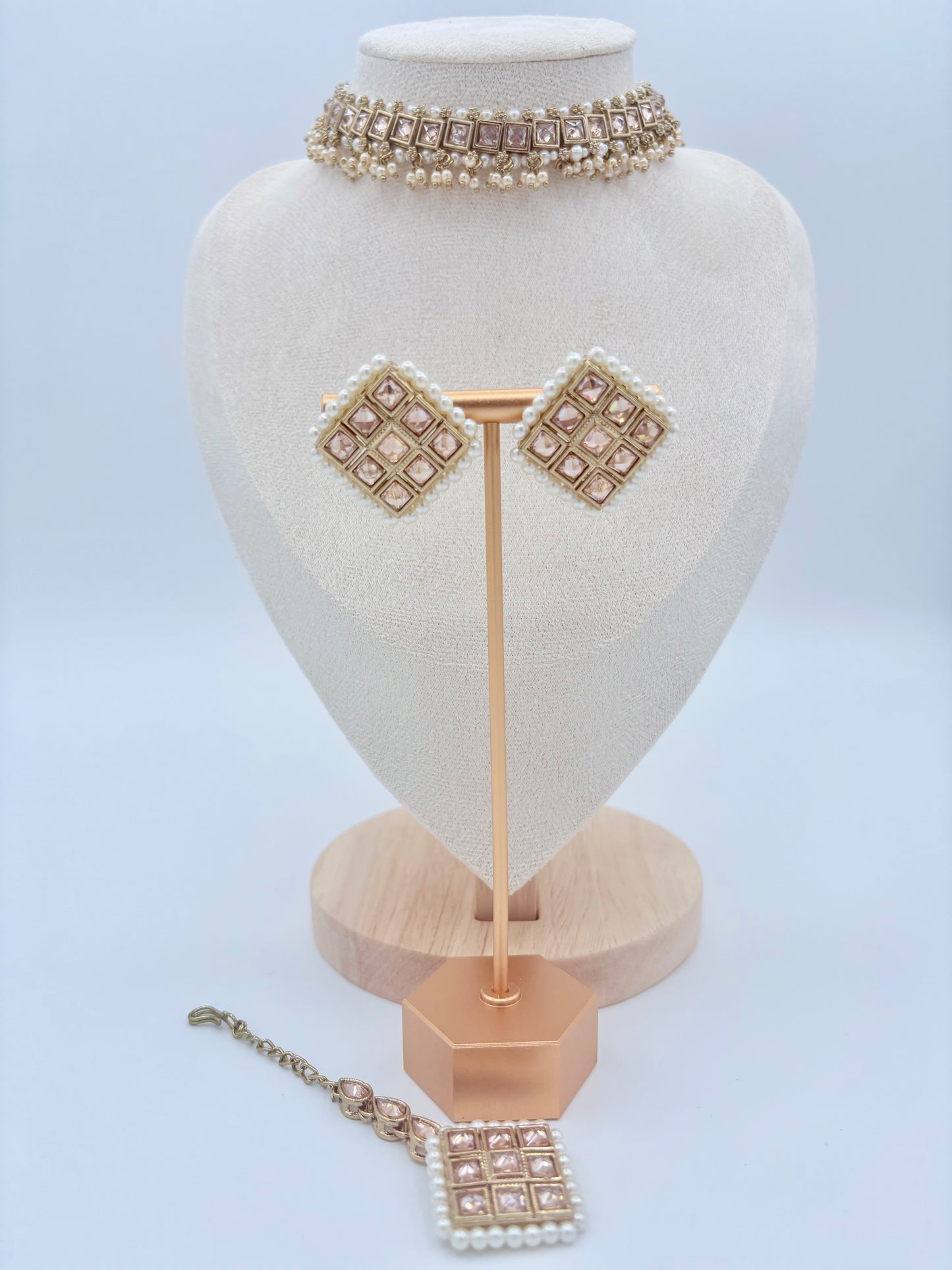 Set of pearl jewelry including a necklace, tikka, and earrings on a mannequin bust available at Nishaani.ca – Indian jewelry in Canada