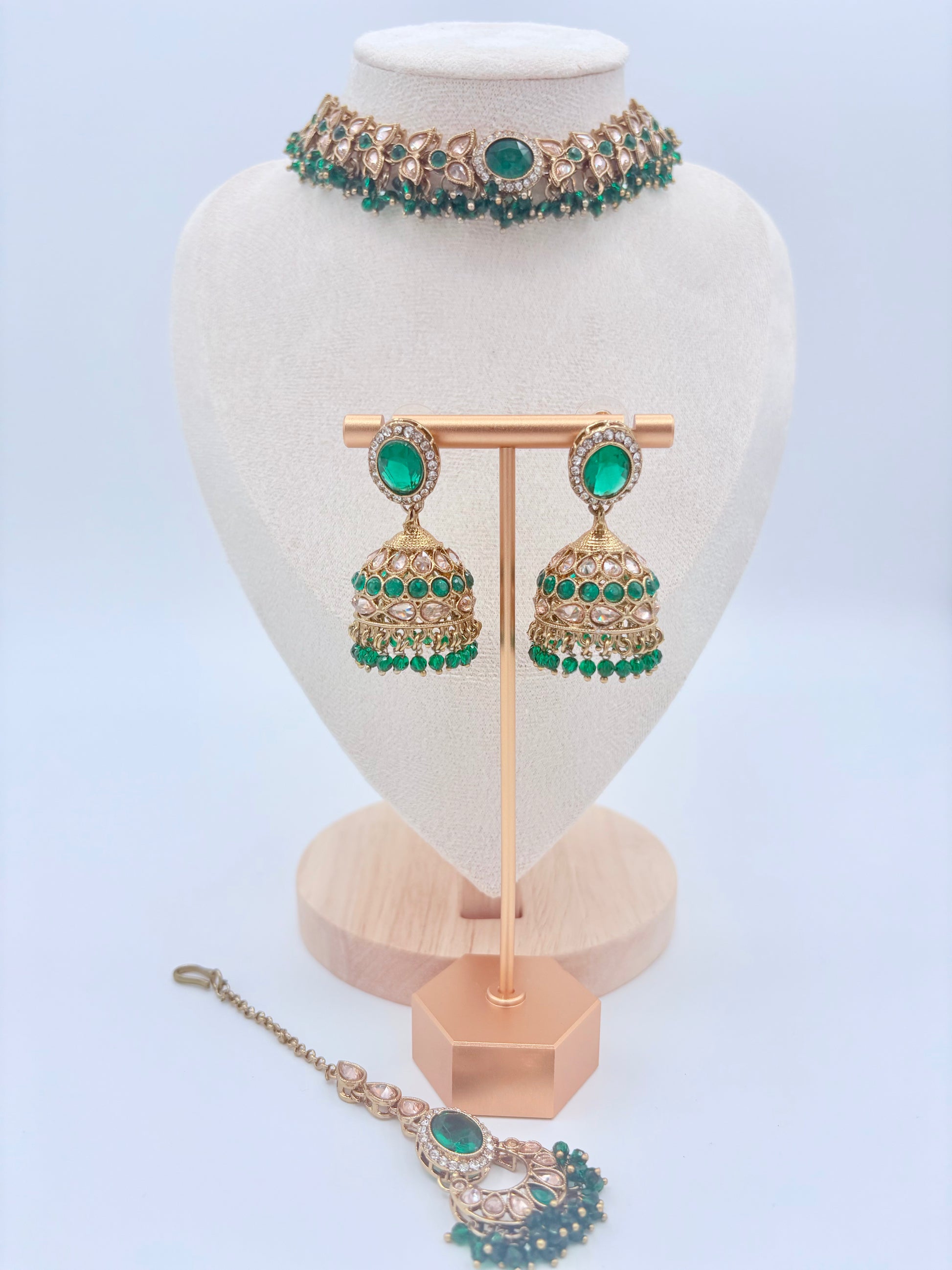 Jewelry set including a choker necklace, earrings, and tikka on a white stand with a available at Nishaani.ca – Indian jewelry in Canada